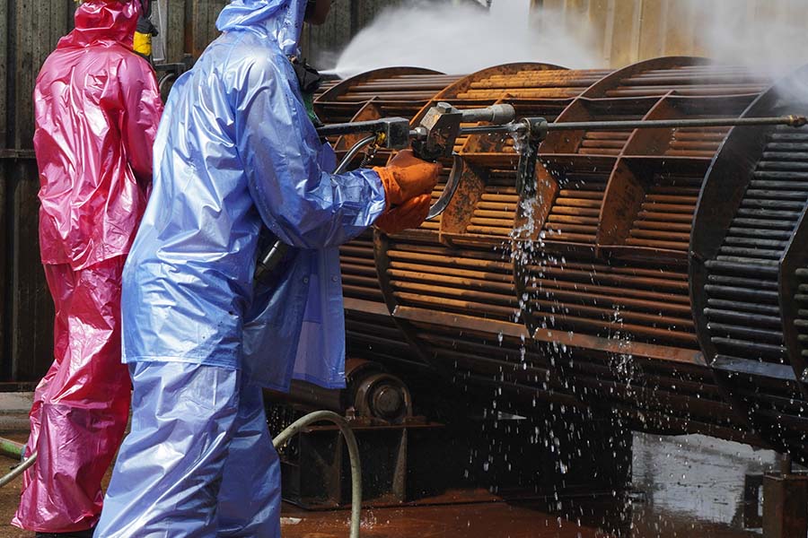 A disinfection team washing down equipment on a poultry farm