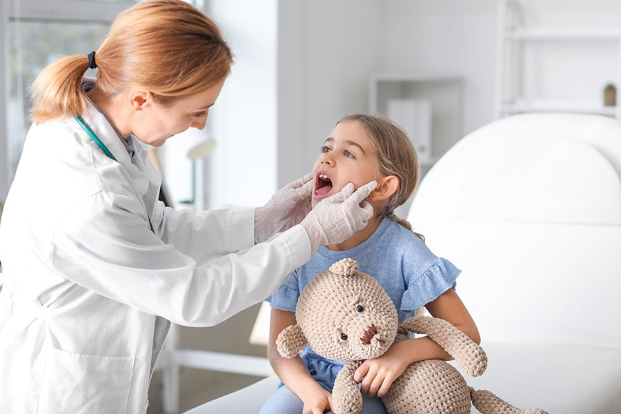 Pediatrician examining little girl with a suspected Strep A infection